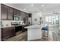 Modern kitchen has stainless appliances, dark cabinets, quartz counters, and island seating with views to the living area at 2511 W Queen Creek Rd # 262, Chandler, AZ 85248