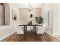 Modern dining room with stylish black table, statement chandelier, and bright window view at 2753 E Kenwood St, Mesa, AZ 85213
