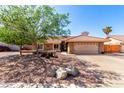 Charming single-story home featuring a two car garage, desert landscaping, and a red tile roof at 2753 E Kenwood St, Mesa, AZ 85213