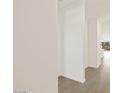 Bright hallway featuring neutral-toned walls and flooring, leading to various areas of the home at 37069 W Prado St, Maricopa, AZ 85138