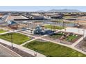 Aerial view showcases a community park with playground, sports courts, a BBQ area, and picnic tables at 37084 W Prado St, Maricopa, AZ 85138