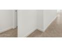 Neutral hallway with ceramic tile flooring, white trim, and simple architectural details at 37084 W Prado St, Maricopa, AZ 85138
