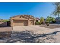 Attractive single-story home featuring a large driveway leading to a three-car garage and desert landscaping at 4356 E Carriage Way, Gilbert, AZ 85297