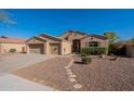 Well-maintained single-Gathering home with a three-car garage, desert landscaping, and a paved walkway at 4356 E Carriage Way, Gilbert, AZ 85297