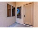 Front entryway featuring a paneled front door, side windows, and neutral-colored stucco walls at 4356 E Carriage Way, Gilbert, AZ 85297
