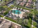 Stunning aerial view of a community pool with palm trees, shaded cabanas, and well-manicured landscaping at 4646 E Maplewood St, Gilbert, AZ 85297