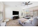 Bright living room with a ceiling fan, tile floors, a sectional sofa, and natural light from large windows at 4646 E Maplewood St, Gilbert, AZ 85297