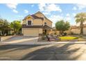 Charming two-story home with a well-manicured lawn and mature landscaping under a bright sky at 4715 E Carmen St, Phoenix, AZ 85044