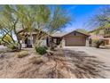 Charming single-story home with a well-maintained front yard and desert landscaping under a clear blue sky at 5537 E Dusty Wren Dr, Cave Creek, AZ 85331