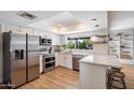 Bright, modern kitchen with white cabinets, stainless steel appliances, and a stylish breakfast bar at 6271 E Evans Dr, Scottsdale, AZ 85254