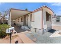 Charming mobile home featuring a covered porch with seating and neat landscaping at 701 S Dobson Rd # 259, Mesa, AZ 85202