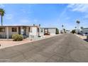 Mobile homes line a street in a well-maintained community under a clear, sunny sky at 701 S Dobson Rd # 259, Mesa, AZ 85202