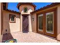 Private front courtyard with brick pavers, a decorative iron gate, and a covered entry at 7159 S Dodane Ct, Gilbert, AZ 85298