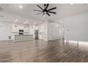 Bright and airy living room with wood-style flooring seamlessly transitions into the modern kitchen at 7234 S 28Th Ln, Phoenix, AZ 85041