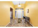 Spacious foyer with bright yellow walls, high ceiling, and tile flooring at 7778 N 51St Ln, Glendale, AZ 85301