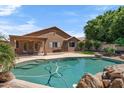 Backyard view of the private in-ground pool with rock features and well-maintained landscaping at 7778 N 51St Ln, Glendale, AZ 85301