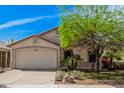 Well-maintained home with a two-car garage, desert landscaping, and mature trees providing shade in a sunny environment at 9309 E Obispo Ave, Mesa, AZ 85212