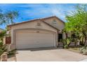 A single Gathering home with a two car garage, desert landscaping, and desert plants at 9309 E Obispo Ave, Mesa, AZ 85212