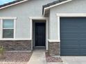 Inviting home entrance features a dark door and low maintenance rock landscaping at 17425 W Eva St, Waddell, AZ 85355