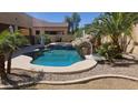 Inviting backyard pool features rock waterfall and lush landscaping, creating a private oasis for relaxation and recreation at 2018 W Whisper Rock Trl, Phoenix, AZ 85085