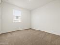 Clean bedroom with a neutral carpet, a window, and fresh white walls at 37341 W San Clemente St, Maricopa, AZ 85138
