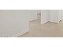 Bright hallway with neutral tile flooring and white walls, leading to other rooms at 37341 W San Clemente St, Maricopa, AZ 85138