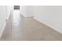 Bright hallway featuring neutral-colored tile flooring and leads into other rooms at 37373 W San Clemente St, Maricopa, AZ 85138