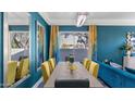 Elegant dining room with a long table, stylish chairs, and vibrant turquoise walls at 3956 S Hollyhock Pl, Chandler, AZ 85248