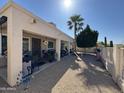 Home exterior with shaded patio, desert landscaping, palm tree, and fence at 6214 E Sierra Morena St, Mesa, AZ 85215
