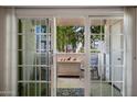 View through glass doors onto the patio with outdoor seating and decorative birds at 8020 E Thomas Rd # 215, Scottsdale, AZ 85251