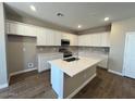 Bright kitchen with white cabinets, a central island, and stainless steel appliances at 2945 S 232Nd Dr, Buckeye, AZ 85326