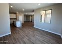Open living space with wood-look floors connecting the kitchen and dining areas at 2945 S 232Nd Dr, Buckeye, AZ 85326