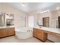 Bathroom featuring a sunken tub with step-up, dual vanities, and a large mirror at 4029 W Grandview Rd, Phoenix, AZ 85053