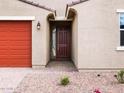 Close-up of the home's entrance featuring a six-panel front door, brick walkway, and low-maintenance desert landscaping at 4348 W Hannah St, San Tan Valley, AZ 85144