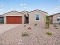 Well-maintained single-story home featuring a red garage door and a neatly landscaped front yard with desert flora at 4348 W Hannah St, San Tan Valley, AZ 85144