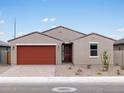 Inviting single-story home with a red two-car garage, desert landscaping, and a well-maintained front yard at 4348 W Hannah St, San Tan Valley, AZ 85144