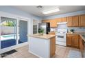 Functional kitchen with an island, stainless steel refrigerator, ample cabinetry, and access to the backyard pool area at 11501 W Charter Oak Rd, El Mirage, AZ 85335
