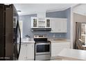 Charming kitchen with white cabinetry, stainless steel appliances, and plenty of counter space at 201 S Greenfield Rd # 51, Mesa, AZ 85206
