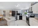 Open kitchen with white cabinets, black appliances, and a central island at 201 S Greenfield Rd # 51, Mesa, AZ 85206