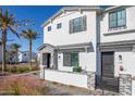 Inviting two-story townhouse featuring desert landscaping, gray brick accents, and a charming white stucco exterior at 669 E Scenic St, Apache Junction, AZ 85119