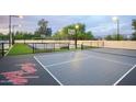 Multi-sport court with basketball, pickleball, and volleyball, lit for evening play with dusk sky above at 6718 E Caron Dr, Paradise Valley, AZ 85253