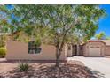 Exterior side view of a beige home with red rock landscaping and desert foliage at 9259 W Caron Cir, Peoria, AZ 85345