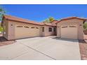 Exterior view of a home with a three car garage and a desert landscape at 9259 W Caron Cir, Peoria, AZ 85345