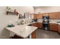 Modern kitchen featuring granite countertops, wooden cabinets, and stainless steel appliances at 9646 N 94Th Ave, Peoria, AZ 85345