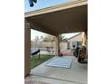 Inviting covered patio with a blue striped rug, offering a relaxing outdoor space overlooking the backyard at 9646 N 94Th Ave, Peoria, AZ 85345