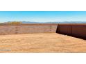 Large undeveloped backyard with a block wall, offering a blank canvas for landscaping and customization at 11912 E Aster Ln, Florence, AZ 85132