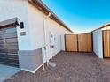 Side view of a home with a two-car garage and a wooden fence, providing backyard access at 11912 E Aster Ln, Florence, AZ 85132