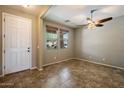 Inviting room featuring tile floors, neutral walls, a ceiling fan and natural light from two windows at 12217 W Planada Ln, Sun City, AZ 85373