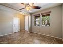 Bright room featuring tile floors, neutral walls, a ceiling fan and natural light from two windows at 12217 W Planada Ln, Sun City, AZ 85373
