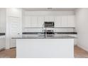 Modern kitchen with white cabinetry, granite countertops, and stainless steel appliances at 12473 E Bahia Ct, Florence, AZ 85132
